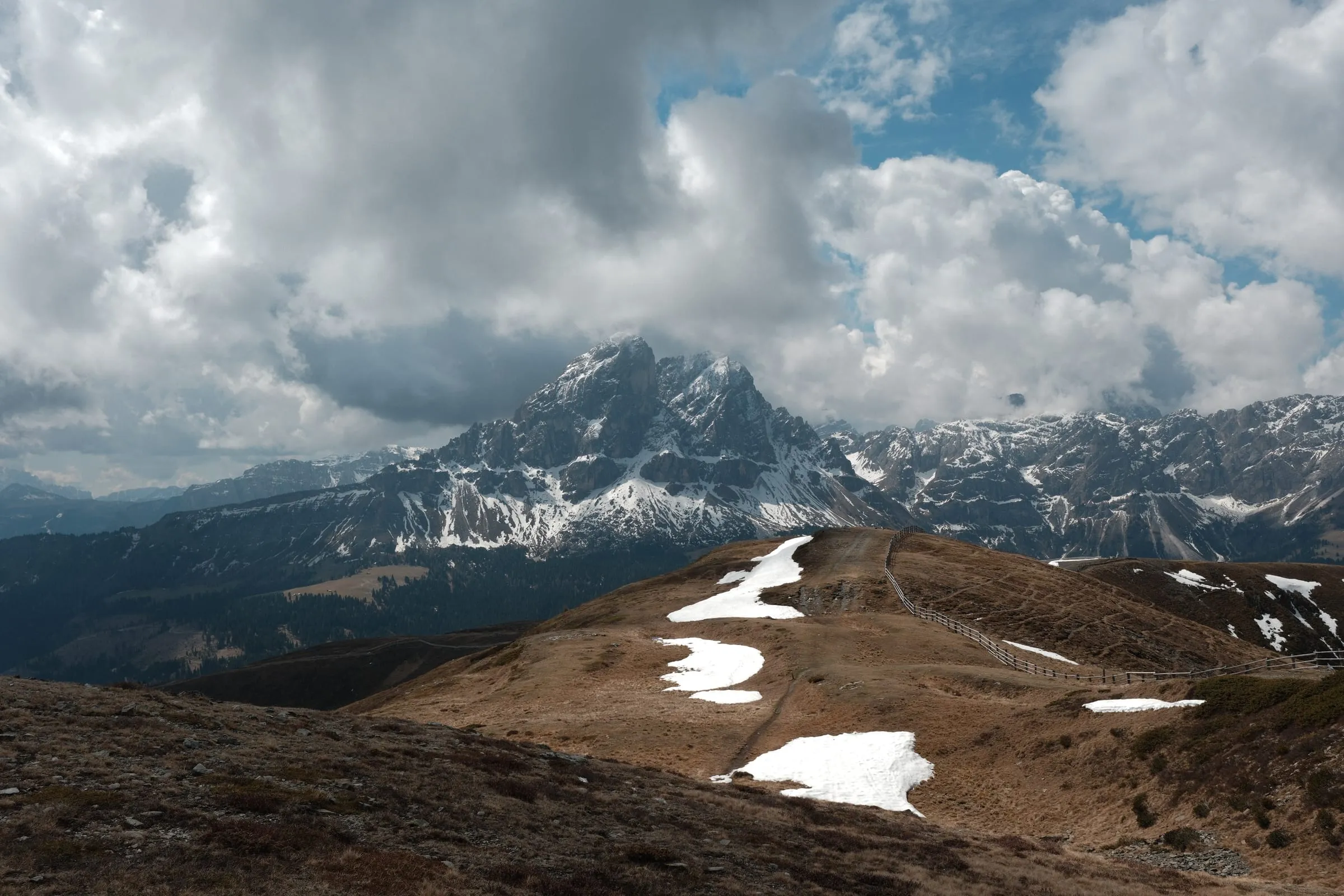 Der Peitlerkofel unter tiefen Wolken, Schneereste auf dem Grat davor