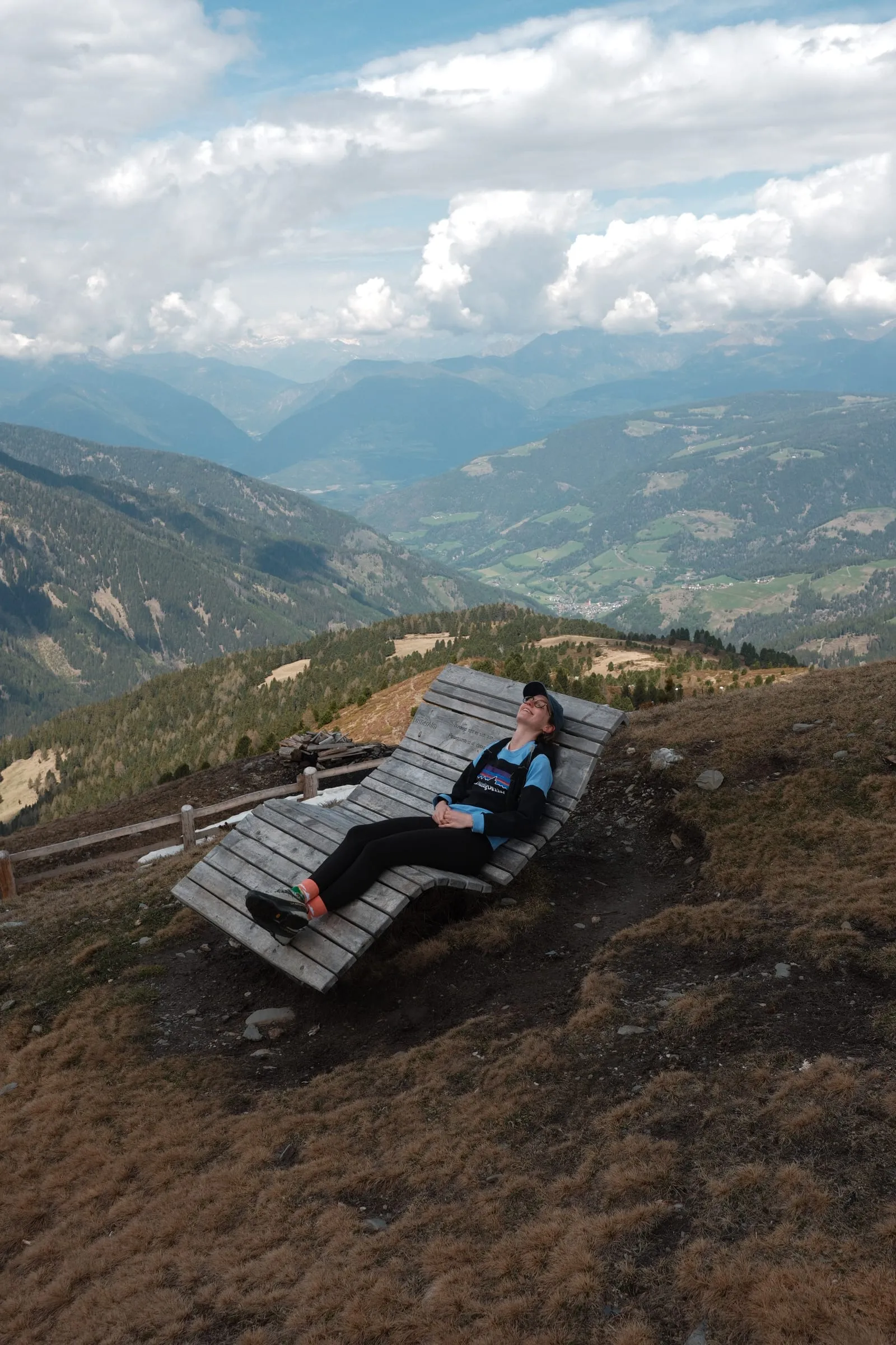 Rast auf einer großen Holzliege mit Blick hinunter ins Tal